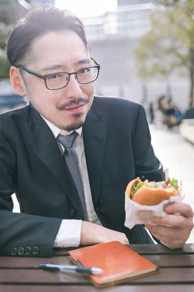 ハンバーガーを食すグルメライターの写真