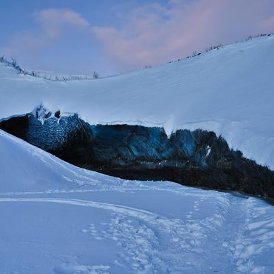 雪山に開いた氷の洞窟の写真