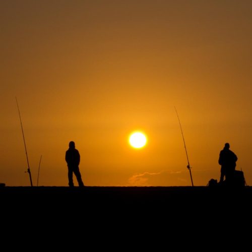 Fisherman silhouettes during sunset