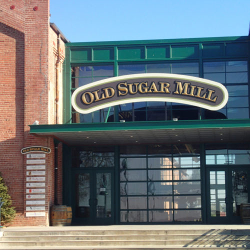 Storefront view of the Old Sugar Mill with sign