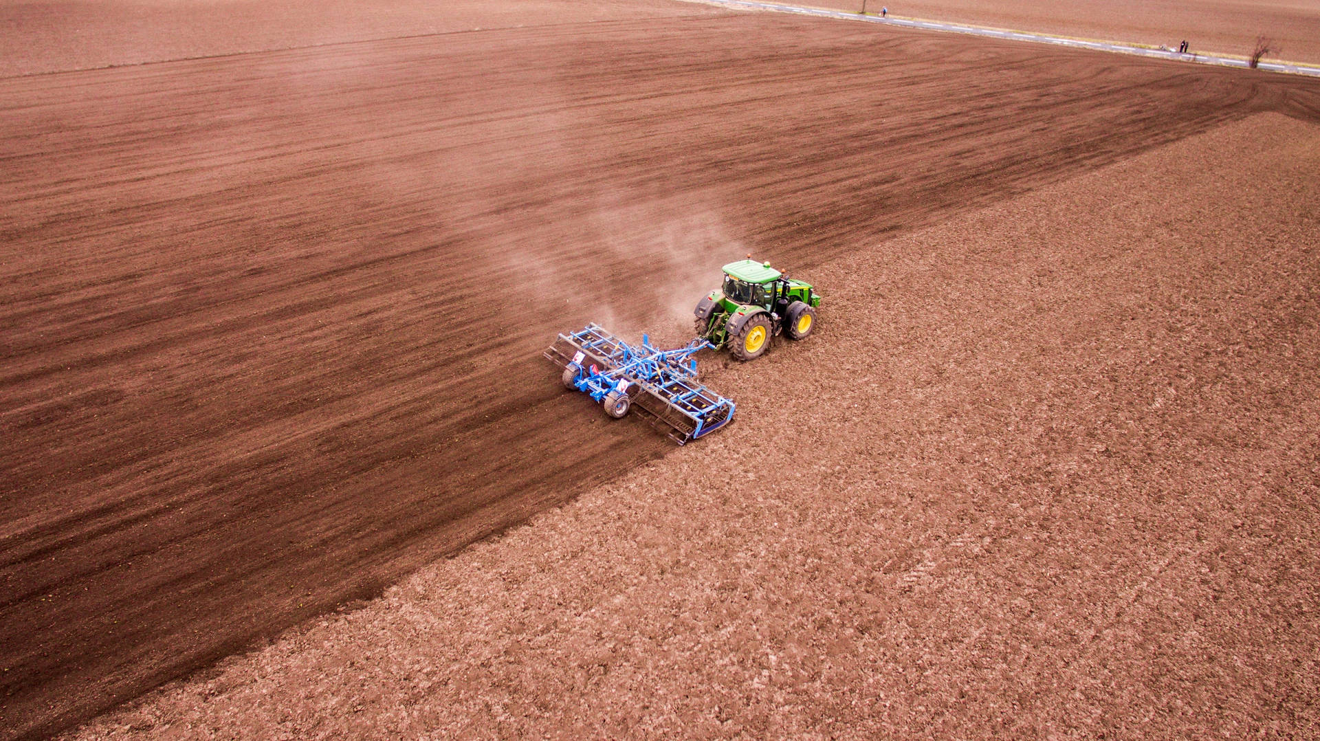 Groundbreaking Performance: John Deere Tractor in Vast Field Wallpaper