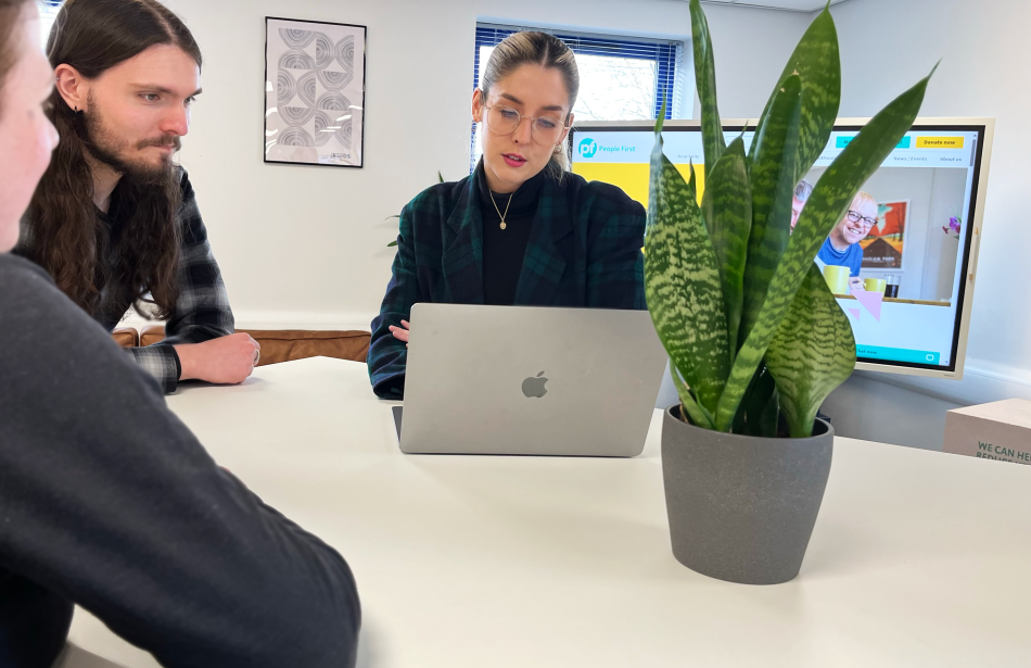 Reeds team reviewing a website design around a table in the Carlisle studio