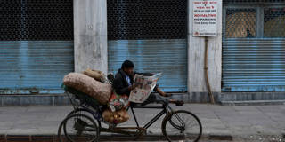 Rickshaw driver reads paper