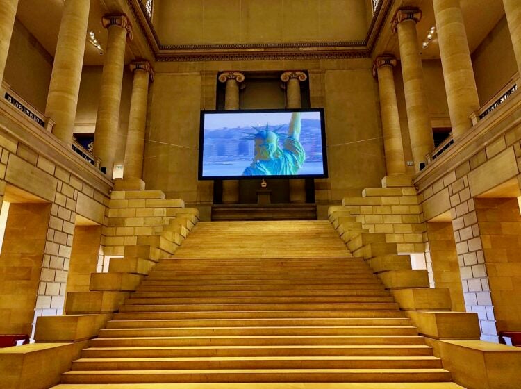 Filmmaker Steve McQueen's ''Static,'' a 7-minute helicopter shot of the Statue of Liberty filmed in 2009 when it reopened for the first time since the 9/11 attacks, occupies the Grand Staircase of the Philadelphia Museum of Art. (Peter Crimmins/WHYY)