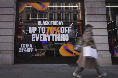 A shopper passes a store advertising a Black Friday Sale. (Kirsty Wigglesworth/AP)