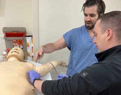 Dr. Vadym Serdiuchenko is guided through a tube thoracostomy procedure by Dr. Joseph Leanza. (Karyn Miller-Medzon/Here & Now)