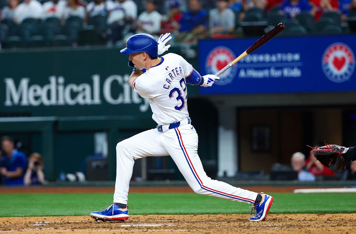 exas Rangers outfielder Evan Carter (32) hits an rbi single during the eighth inning against the Washington Nationals at Globe Life Field.