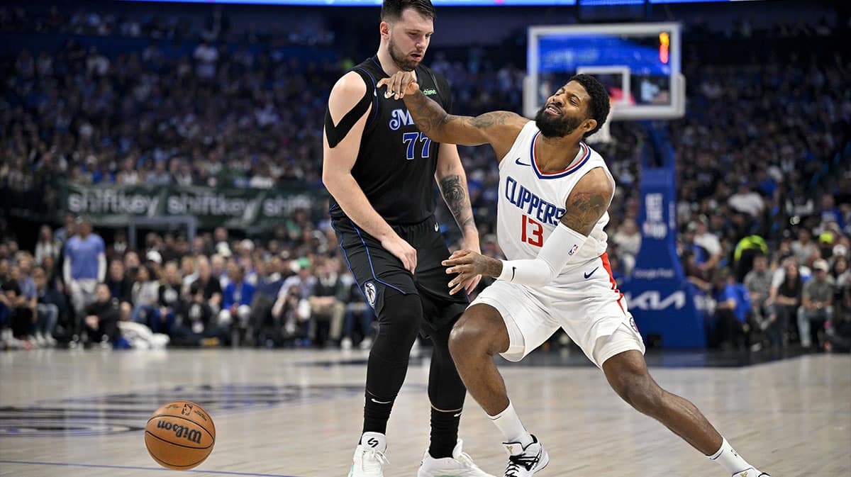  LA Clippers forward Paul George (13) is fouled by Dallas Mavericks guard Luka Doncic (77) during the first quarter during game six of the first round for the 2024 NBA playoffs at American Airlines Center.