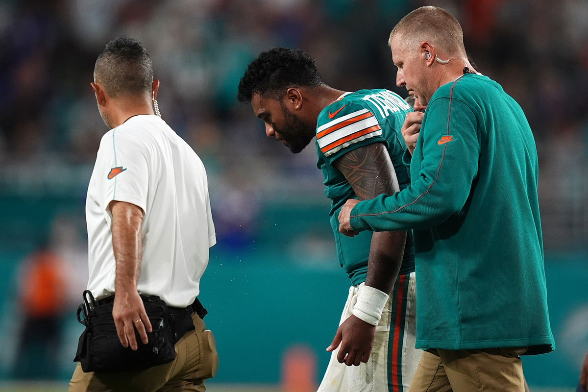 Miami Dolphins quarterback Tua Tagovailoa (1) walks off the field with training staff after an apparent injury during the second half against the Buffalo Bills at Hard Rock Stadium.