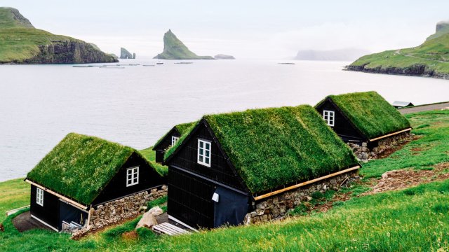 Article thumbnail: Houses near the small village of Bour, with Drangarnir and Tindholmur on background (Photo: Francesco Riccardo Iacomino/Getty Images)