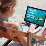 Article thumbnail: travel insurance online concept, tourist looking at the screen of computer