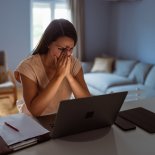 Article thumbnail: Female victim of financial fraud, looking anxious. She is at her home, discovering financial fraud