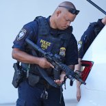 Article thumbnail: A Department of Homeland Security officer loads his weapon as he patrols outside the Paul G. Rogers Federal Building and U.S. Courthouse, where a man suspected in an apparent assassination attempt targeting former President Donald Trump, was charged with federal gun crimes, Monday, Sept. 16, 2024, in West Palm Beach, Fla. (AP Photo/Wilfredo Lee)