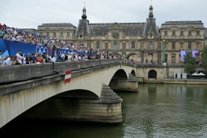 Spectators sit on seats in the stand on the Pont du Carrousel ahead of the opening ceremony of the Paris 2024 Olympic Games