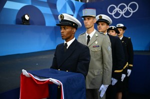 Army officials carry the French flag during the opening ceremony of the Paris 2024 Olympic Games