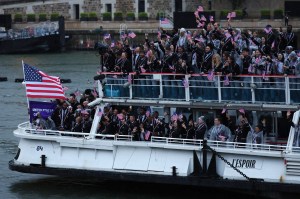 Athletes of Team United States wave flags on the athletes' parade team boat along the River Seine during the opening ceremony of the Olympic Games Paris 2024