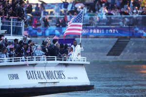 Lebron James, Flagbearer of Team United States, waves his country's flag on a boat on the River Seine during the opening ceremony of the Olympic Games Paris 2024