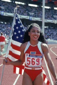 Florence Griffith Joyner of the USA walks with the American Flag as she celebrates setting a new Olympic record to win the gold medal in the Women's 100 meters dash final during the 1988 Summer Olympic Games on September 28, 1988 in Seoul, Korea.