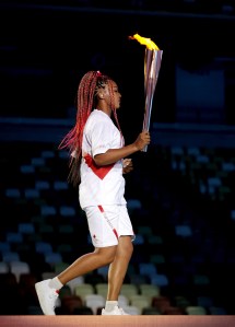 Naomi Osaka of Team Japan carries the Olympic torch towards the Olympic cauldron during the Opening Ceremony of the Tokyo 2020 Olympic Games at Olympic Stadium on July 23, 2021 in Tokyo, Japan.