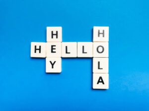 Scrabble tiles that spell out English and Spanish words "Hey, Hello, Hola"