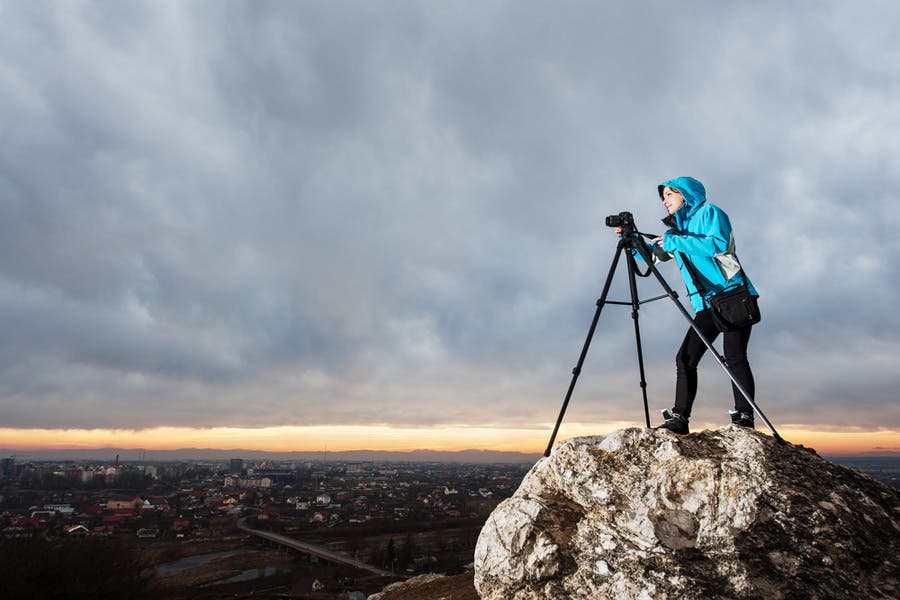 Photographer shooting from edge of rocky mountain