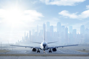 Airplane on runway with foggy city in the background