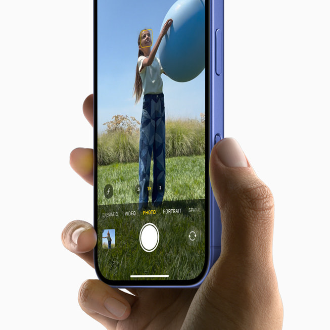 A user captures a photo of a person holding a ball with iPhone 16.