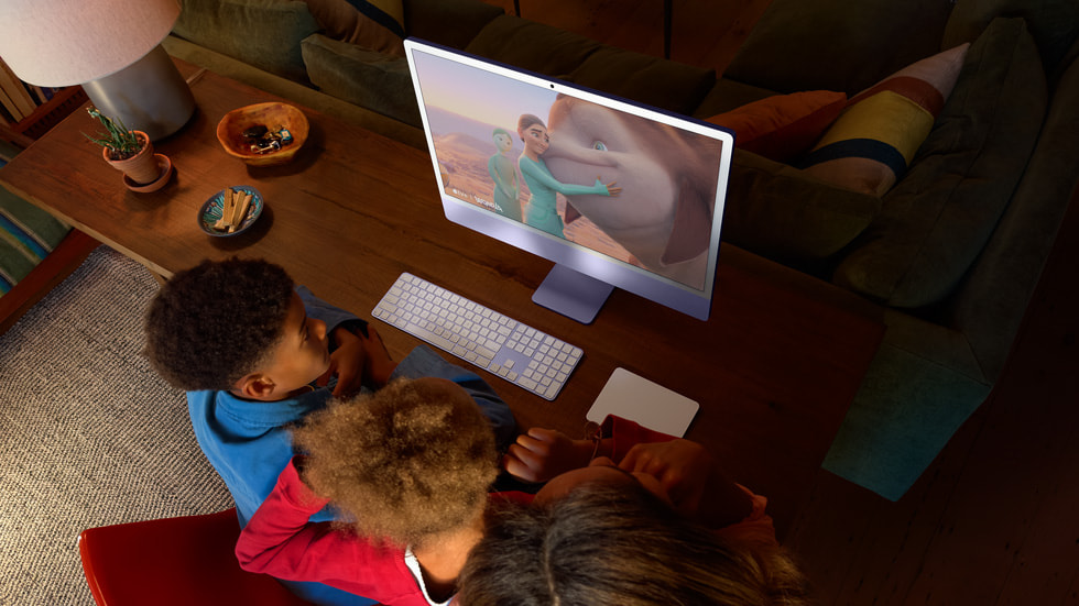 Three people watch a scene from an animated movie on iMac.