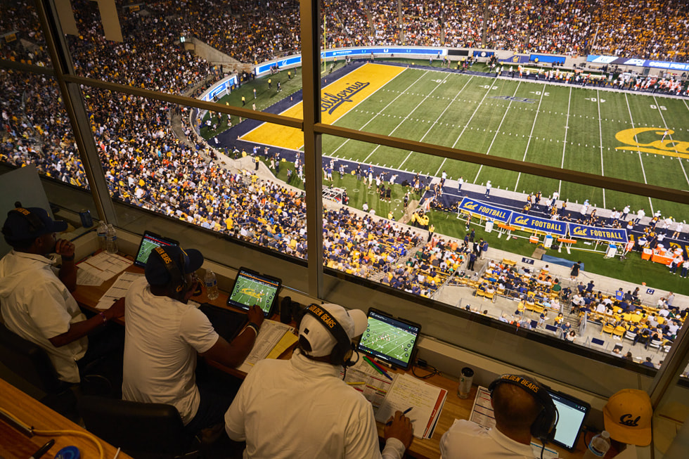 Cal coaching staff review footage on iPad in a booth high above the football field.