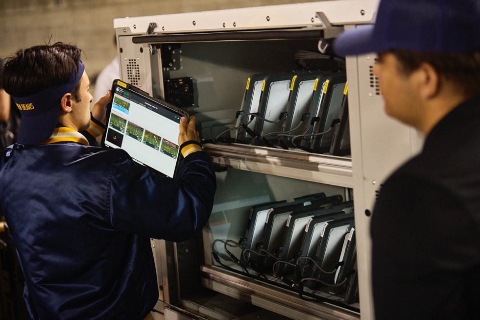 Cal’s tech team stands next to a locker where the team’s iPad devices are stored.