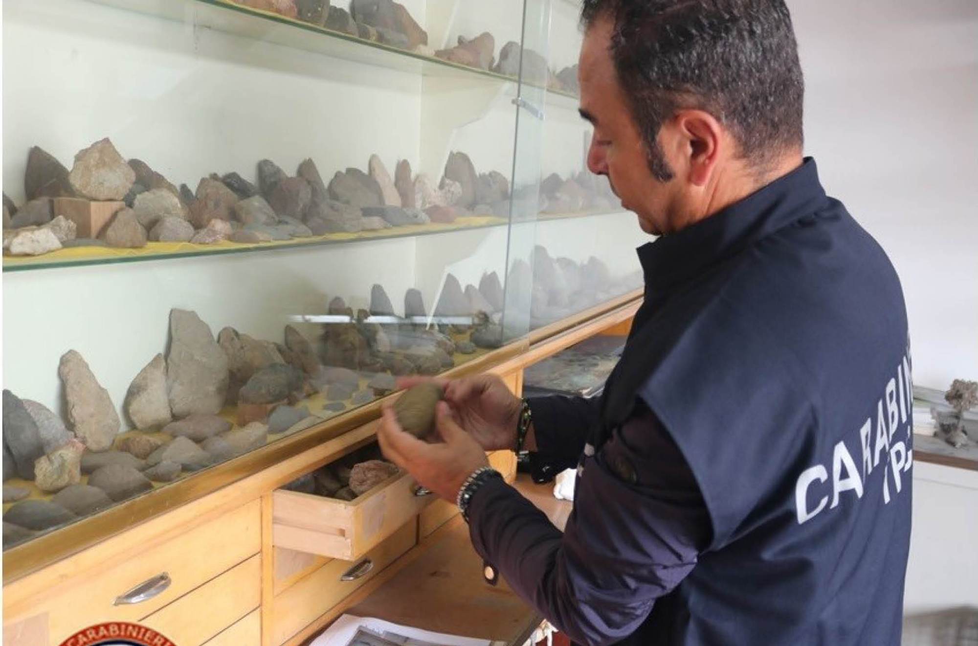 A man looks at recently recovered ceramic and lithic artifacts.