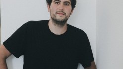 A man with a short beard in a black T-shirt.