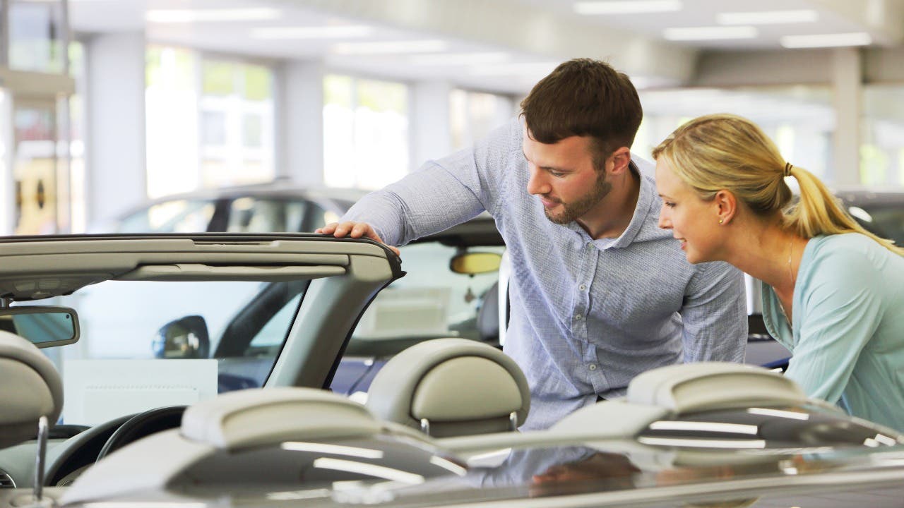 Couple looks at a car at a dealership