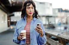 Young person walking and using smart phone