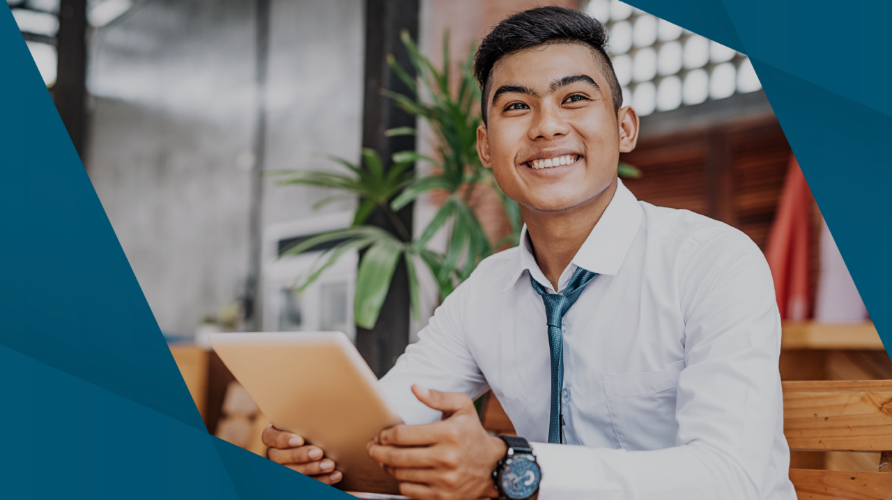 young man smiling holding tablet