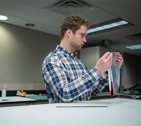 Employee in a blue plaid shirt with flexible packaging