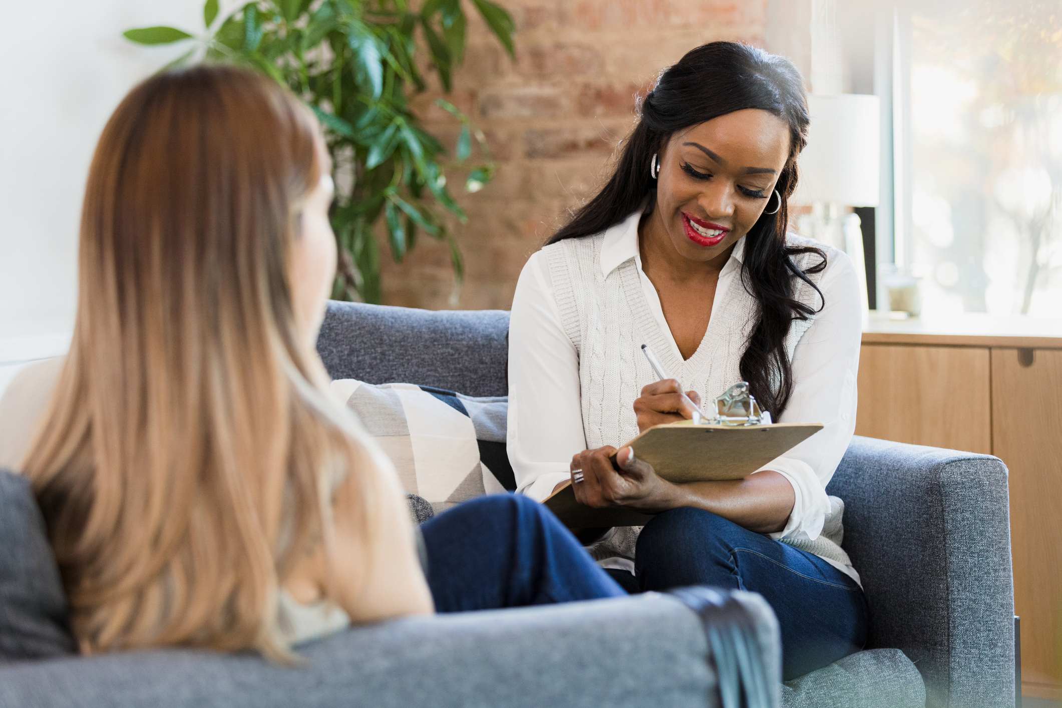 Woman-writing-down-on-notepad-while-doing-job-interview-internal-interview-questions