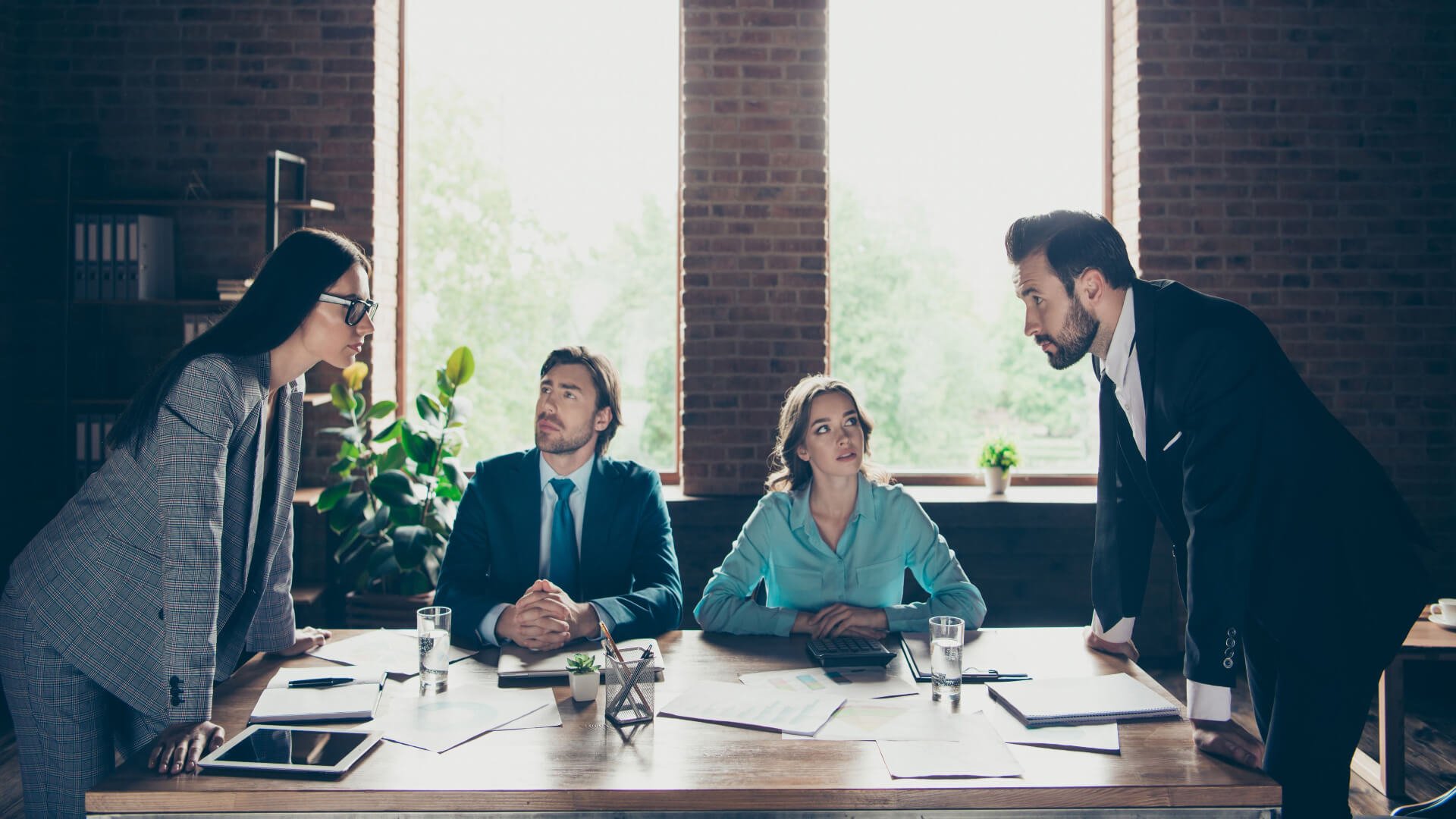 two-people-facing-off-across-table-boss-vs-leader