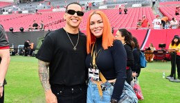 Daddy Yankee and Mireddys González pose for a photo on the field before the game between the Tampa Bay Buccaneers and the Carolina Panthers at Raymond James Stadium on Jan. 1, 2023 in Tampa, Florida.