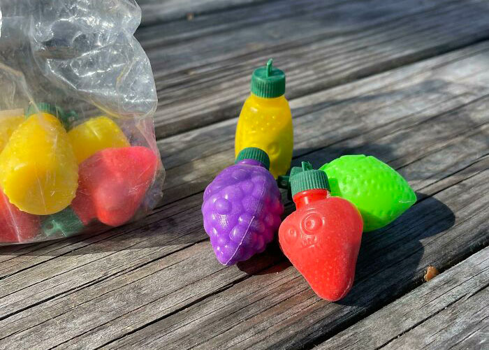 Colorful 90s fruit-shaped drinks on a wooden table, evoking nostalgia from the past.