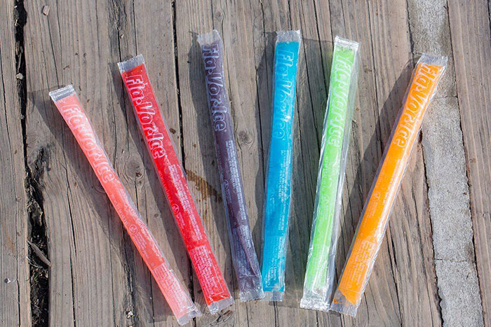 Six colorful 90s nostalgic ice pops on a wooden surface.