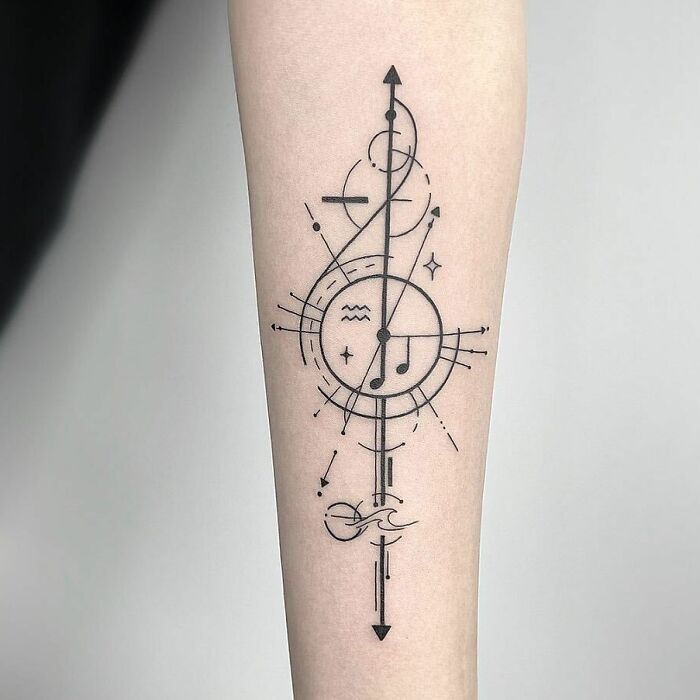 Geometric forearm tattoo featuring musical notes and abstract lines.