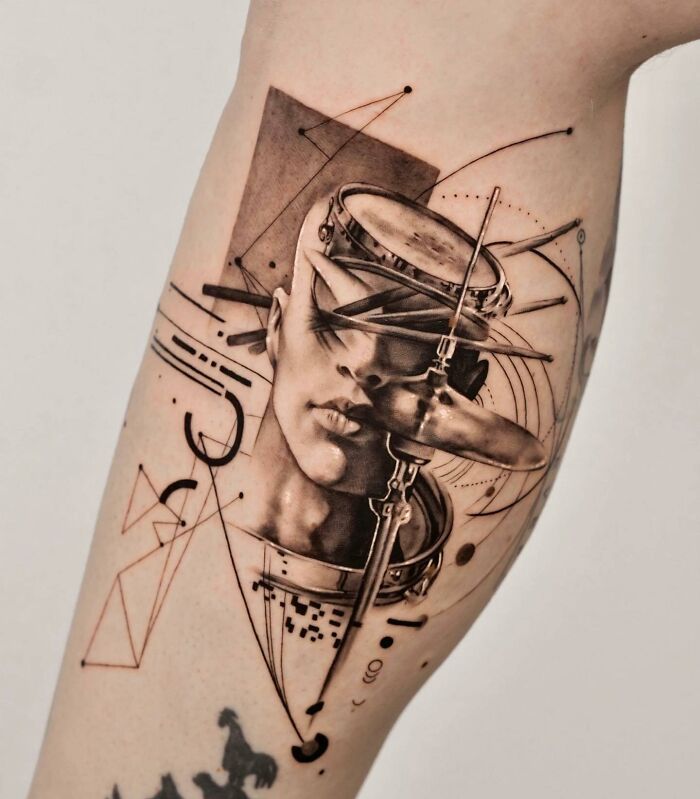 Abstract music tattoo featuring a face, drum, and cymbal with geometric patterns on an arm.