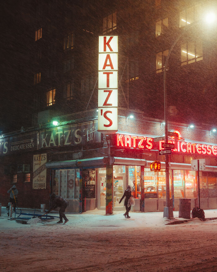 Snowfall outside Katz's Delicatessen, capturing a vibrant street scene; an incredible world photo.