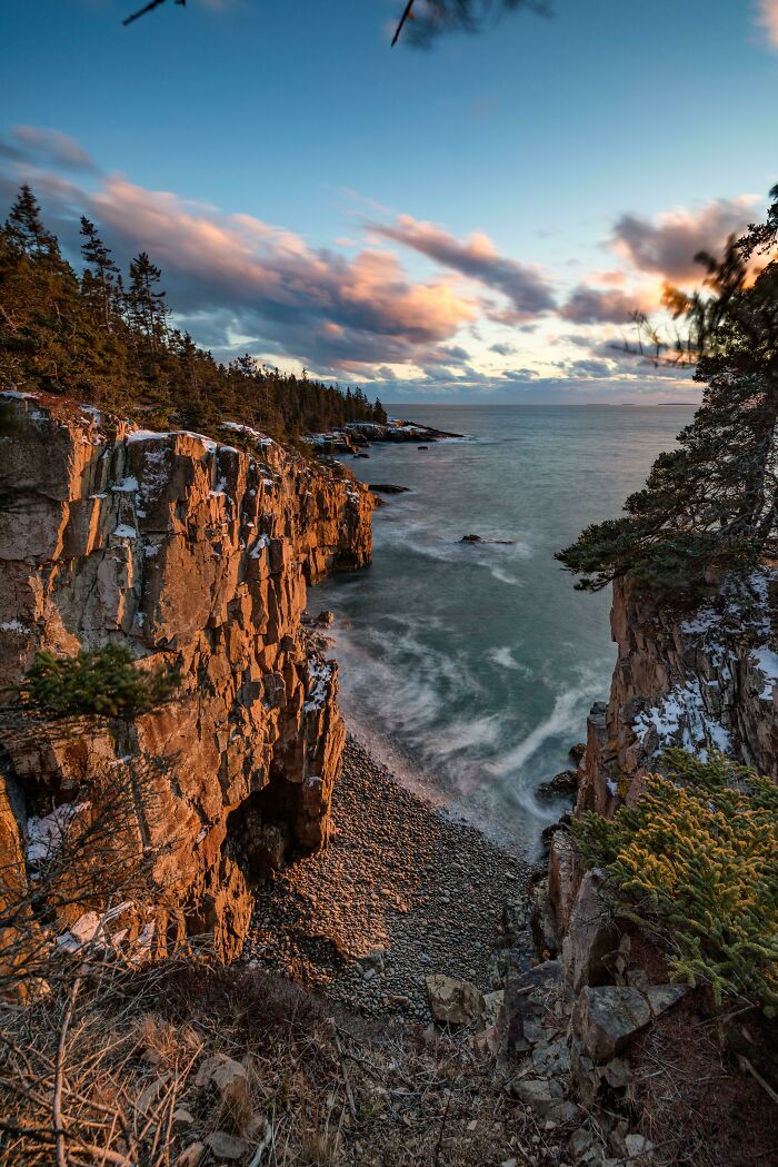 Cliffside view with ocean waves and vibrant sky, showcasing the beauty of incredible world photos.