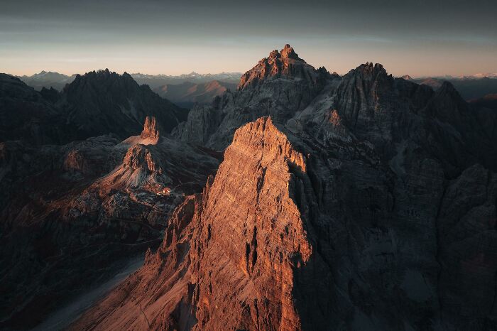 Aerial view of rugged mountain peaks at sunset, showcasing breathtaking scenery.