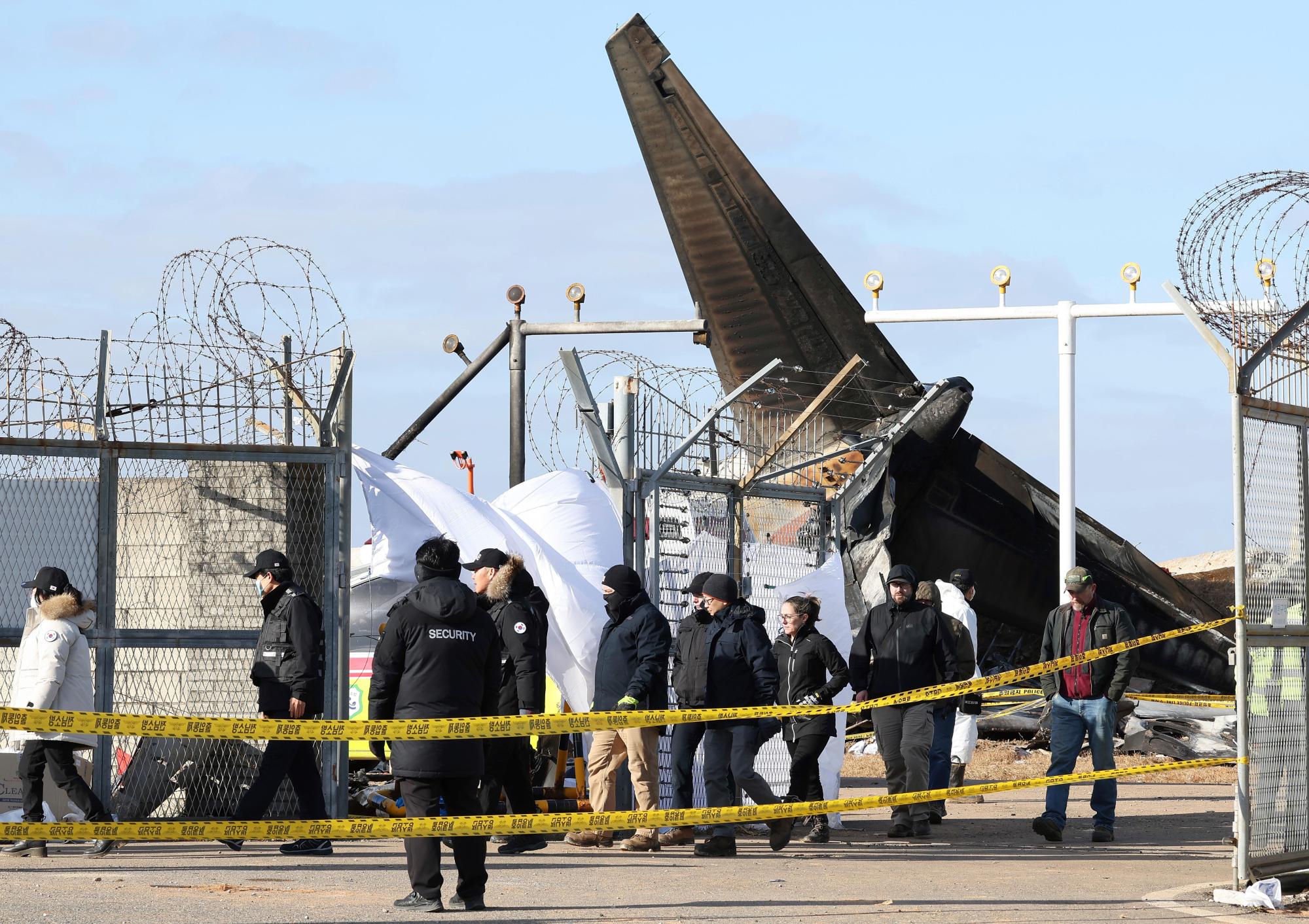 Experts from the U.S. NTSB and from Boeing Co. investigate the site of a plane crash in South Korea