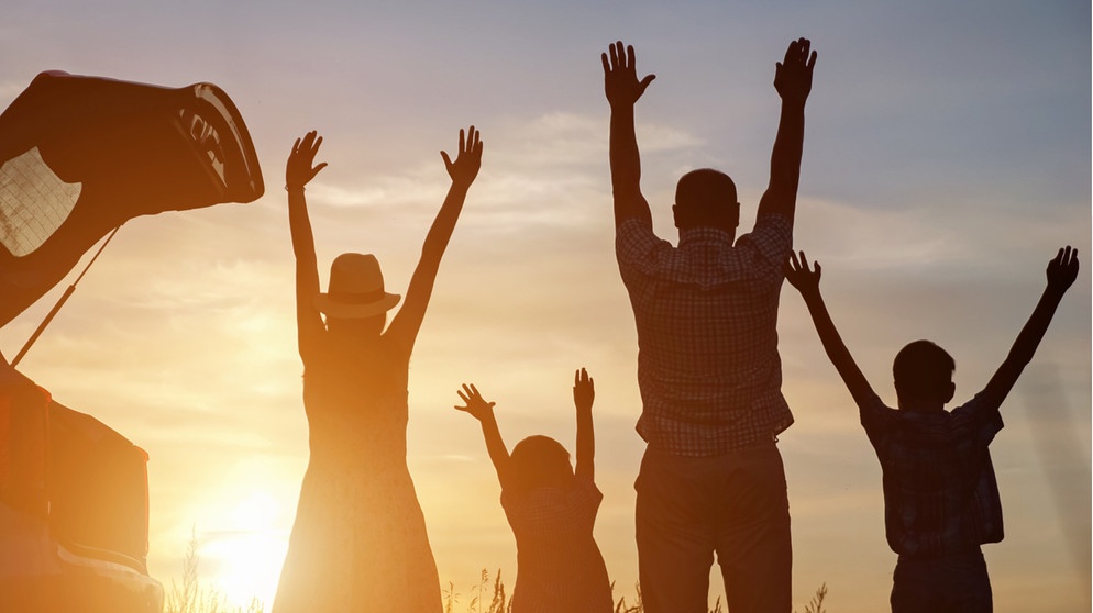 Eltern und zwei Kinder heben die Arme hoch, sie sind als Silhouetten zu sehen und genießen den Sonnenuntergang. Was macht eine gute Eltern-Kind-Beziehung aus? Einige Verhaltensweisen helfen euch dabei, eine positive Bindung zu euren Kindern herzustellen und euer Verhältnis zu festigen.  | Bild: Wochit/Getty Images