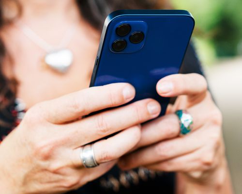 woman holding blue iphone