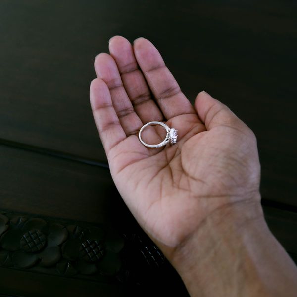 Woman Holding Silver Diamond Wedding Ring in Palm of Hand